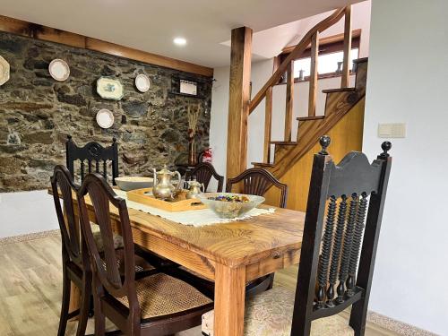 a dining room with a wooden table and chairs at Casa da Barriada II in Bragança