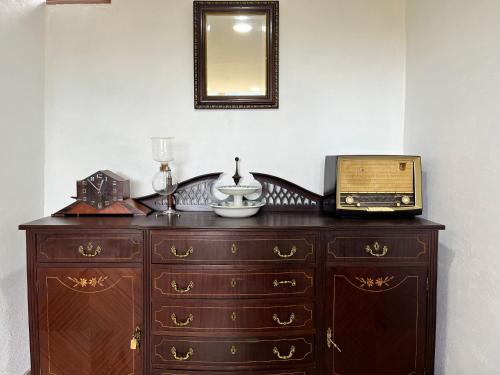 eine Holzkommode mit einem Radio und einem Spiegel in der Unterkunft Casa da Barriada II in Bragança