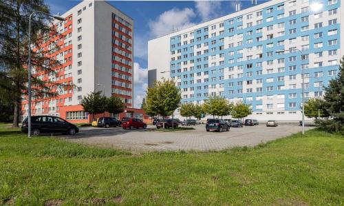 un estacionamiento con autos estacionados frente a edificios altos en Hotel Garni VŠB en Ostrava