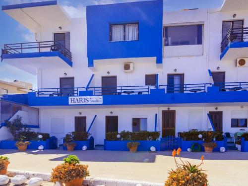 a building with blue balconies and plants in a courtyard at Haris Studios in Palaiochóra