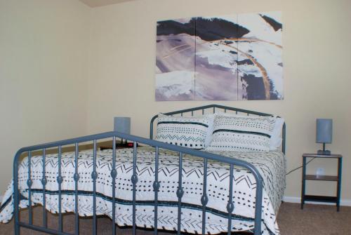 1 dormitorio con 1 cama y una pintura en la pared en Cool & Comfy Condo! Family Friendly!, en College Station