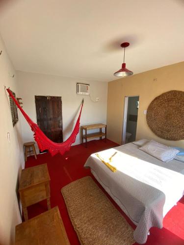 a bedroom with a bed and a hammock in it at Chalé do Coqueiro in Luis Correia