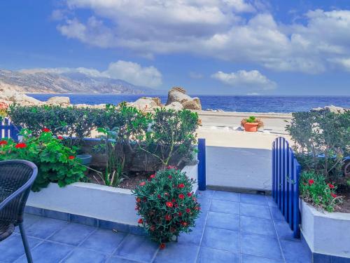 a patio with flowers and a view of the ocean at Haris Studios in Palaiochóra