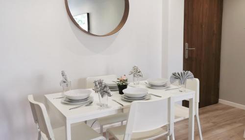 a white dining room table with white chairs and a mirror at App12, Mulhouse centre 4 Personnes in Mulhouse
