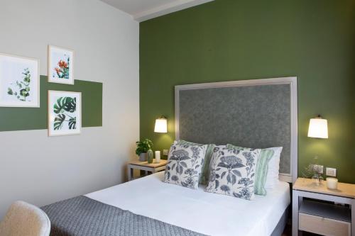 a bedroom with a bed and a green wall at Central Hotel, Trademark Collection by Wyndham in Bucharest