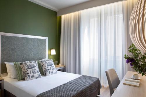 a bedroom with a bed and a desk and a window at Central Hotel, Trademark Collection by Wyndham in Bucharest