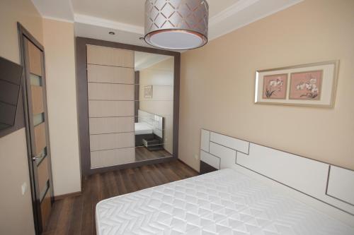 a bedroom with a bed and a large mirror at Apartment with Summer Terrace in Batumi