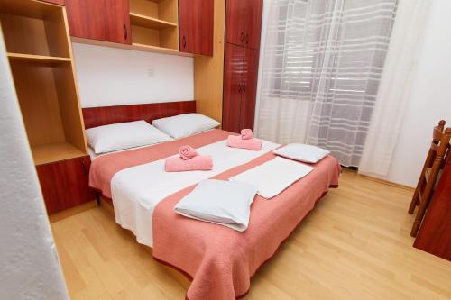 two beds in a room with pink towels on them at Apartments and rooms with parking space Crikvenica - 19125 in Crikvenica