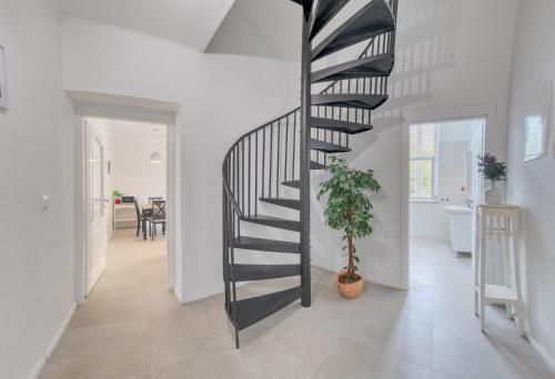 a spiral staircase in a white room with a potted plant at Apartments with parking spaces Kraljevica - 18996 in Kraljevica