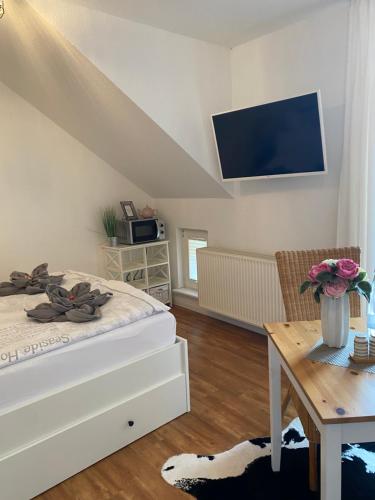 a bedroom with a bed and a table with a tv at Sommerhaus Seidel - mit kostenlosem Parkplatz - in Stralsund