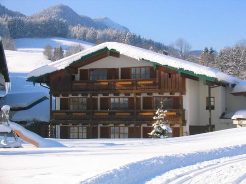 a log cabin with snow on the roof at Landhotel Maiergschwendt inkl Chiemgaukarte in Ruhpolding