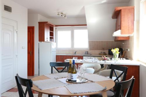 eine Küche mit einem Tisch und einer Flasche Wein in der Unterkunft Teubel apartman 2 in Székesfehérvár