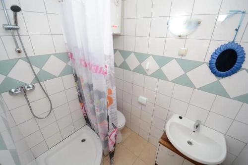 W łazience znajduje się umywalka, toaleta i prysznic. w obiekcie Apartments by the sea Tkon, Pasman - 19024 w mieście Tkon
