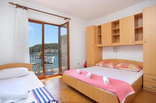 a bedroom with two beds and a balcony at Apartments by the sea Drvenik Donja vala, Makarska - 19006 in Drvenik