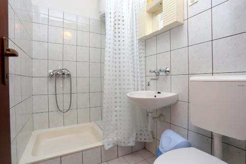 ein Bad mit einer Dusche, einem Waschbecken und einem WC in der Unterkunft Apartments by the sea Drvenik Donja vala, Makarska - 19006 in Drvenik