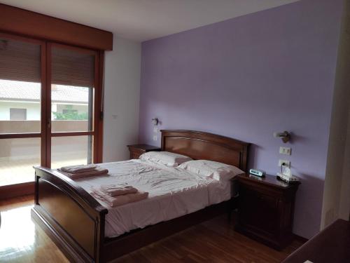 een slaapkamer met een bed en een groot raam bij Casa panoramica in Attimis
