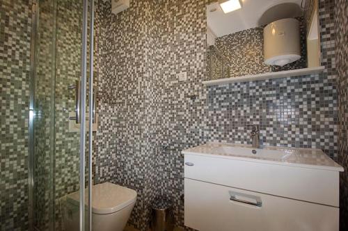 a bathroom with a toilet and a sink and a shower at Apartments by the sea Makarska - 19145 in Makarska