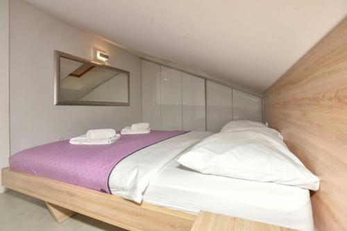 a bedroom with a large bed with white pillows at Apartments by the sea Makarska - 19145 in Makarska