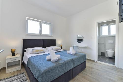 ein Schlafzimmer mit einem großen Bett mit zwei Handtüchern darauf in der Unterkunft Luxury villa with a swimming pool Vrsi - Mulo, Zadar - 19140 in Vrsi