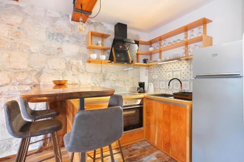 a kitchen with a wooden table and a refrigerator at Apartments with parking space Omis - 19051 in Omiš