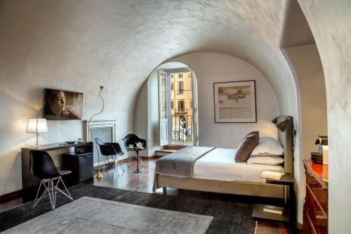 a bedroom with a bed and a desk in a room at Palazzo De Cupis - Suites and View in Rome