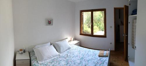 a white bedroom with a bed and a window at Secluded fisherman's cottage Zman, Dugi otok - 19000 in Žman