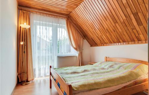 a bedroom with a bed and a large window at 2 Bedroom Pet Friendly Home In Mielno in Mielno