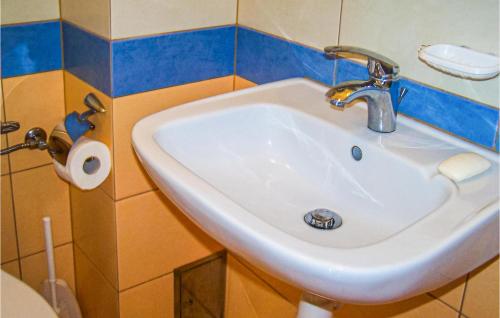 a white sink in a bathroom with a roll of toilet paper at 2 Bedroom Pet Friendly Home In Mielno in Mielno