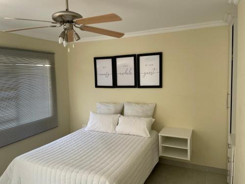 1 dormitorio con 1 cama con 2 almohadas y ventilador de techo en Mafini Villa, en Centurion