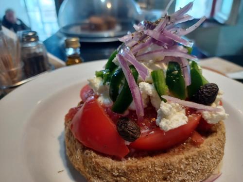 a sandwich with tomatoes and vegetables on a white plate at Haris Studios in Palaiochóra