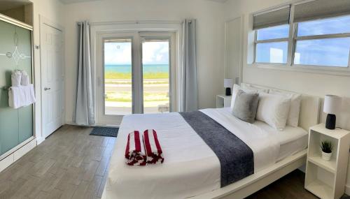 una camera bianca con un grande letto con finestra di A1A Ocean Club a Flagler Beach