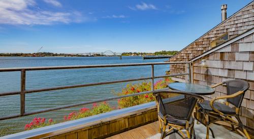 a table and chairs sitting on a balcony overlooking the water at Embarcadero Resort in Newport
