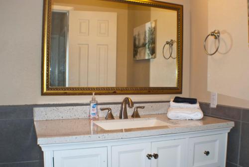 a bathroom with a sink and a mirror at New Family Friendly Stay! No Checkout Work! in College Station