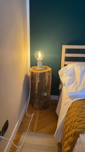a lamp on a tree stump next to a bed at La Petite Maison de la Ville in Turin