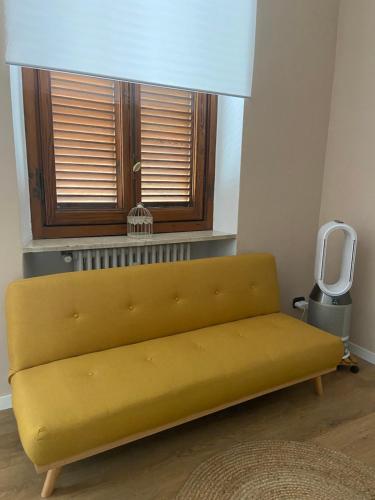 a yellow couch in a room with a window at La Petite Maison de la Ville in Turin