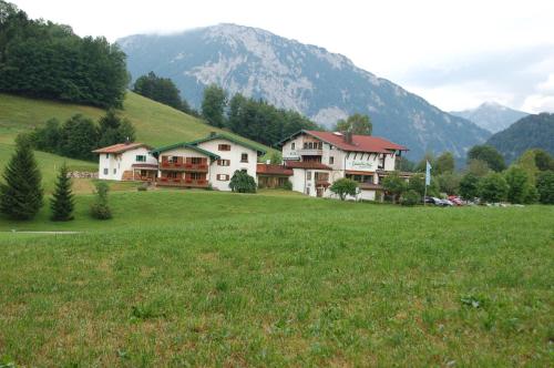 a group of houses on a hill with a field at Landhotel Maiergschwendt inkl Chiemgaukarte in Ruhpolding
