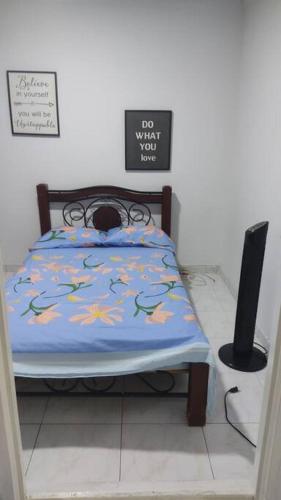 a bedroom with a bed with a blue comforter at Agradable apto independiente con tres cuartos y capacidad para 5 personas, equipada para una agradable estadia in Palmira