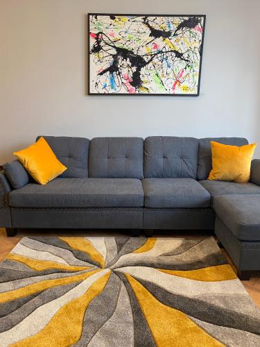 a living room with a blue couch and a rug at Stylish 2 Bed Apt, 2 Minute Walk From The Beach. in Sheringham