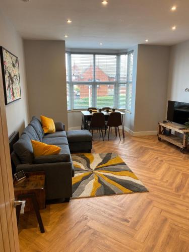 a living room with a couch and a table at Stylish 2 Bed Apt, 2 Minute Walk From The Beach. in Sheringham