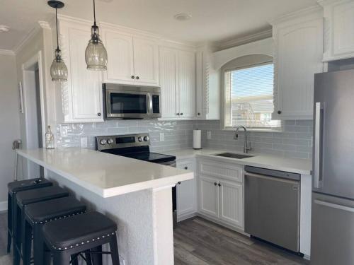 a kitchen with white cabinets and a white counter top at Surfside Beachfront Luxe in Surfside Beach