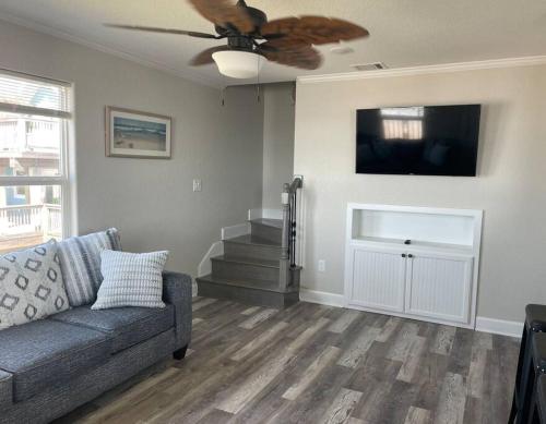 a living room with a couch and a ceiling fan at Surfside Beachfront Luxe in Surfside Beach