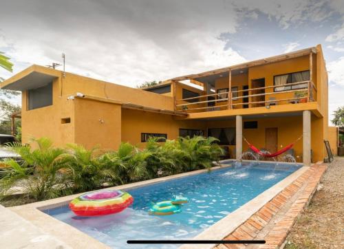 a house with a swimming pool in front of a house at Casa Indica Colombia in Girardot