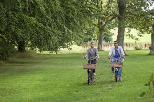 a man and woman riding bikes in a park at Kokkedal Slot Copenhagen in Hørsholm