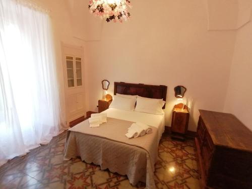 Civico 34, casa tipica salentina في Ortelle: غرفة نوم عليها سرير وفوط