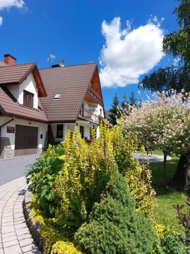 a garden in front of a house with flowers at Czarna Jagoda in Czarna Góra