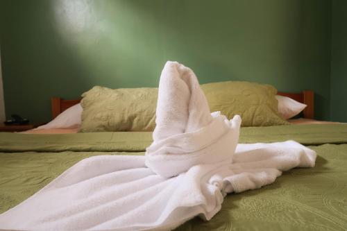 a white towel laying on top of a bed at Hotel Hoja de Oro Corcovado in Puerto Jiménez
