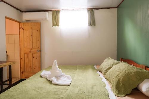 a bedroom with a bed with towels on it at Hotel Hoja de Oro Corcovado in Puerto Jiménez