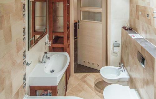 a bathroom with a white sink and a toilet at Stunning Apartment In Miedzyzdroje With 2 Bedrooms And Wifi in Międzyzdroje