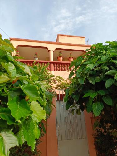 an orange house with a gate and some plants at Résidence Les Fleurettes in Bamako