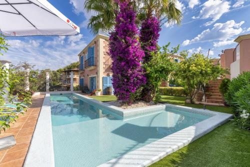 - une piscine dans l'arrière-cour d'une maison ornée de fleurs violettes dans l'établissement Casa Colonial Sitges Hills, à Olivella